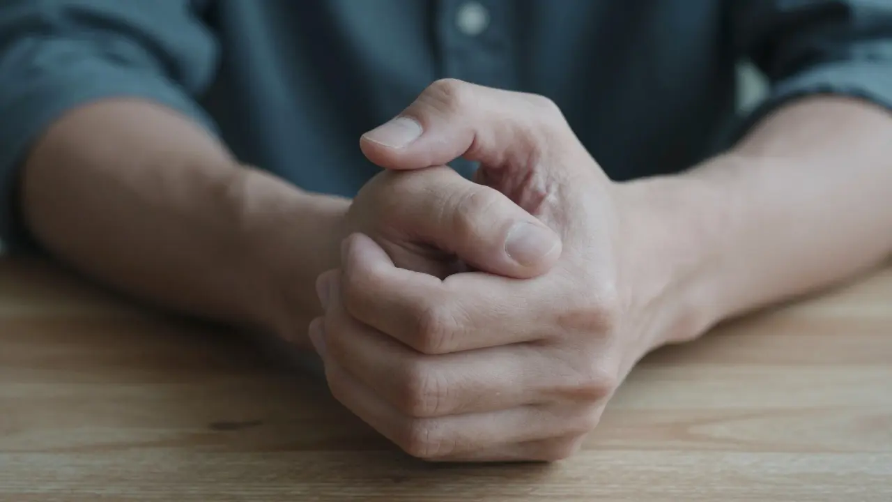 Detailní pohled na třesoucí se ruce člověka s pocitem úzkosti a fyzického napětí.